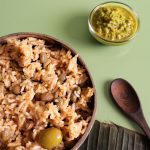 A traditional Puerto Rican dish, Arroz con Gandules, featuring rice and pigeon peas, accompanied by a flavorful sauce.