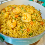 A delicious pot of Puerto Rican shrimp and vegetable rice, perfectly seasoned with homemade Sazón seasoning mix for vibrant color and authentic flavor. The golden yellow rice is infused with Puerto Rican staple seasonings, featuring shrimp, peas, carrots, and peppers. This dish is a perfect example of how to use Sazón seasoning in traditional Latin cooking.