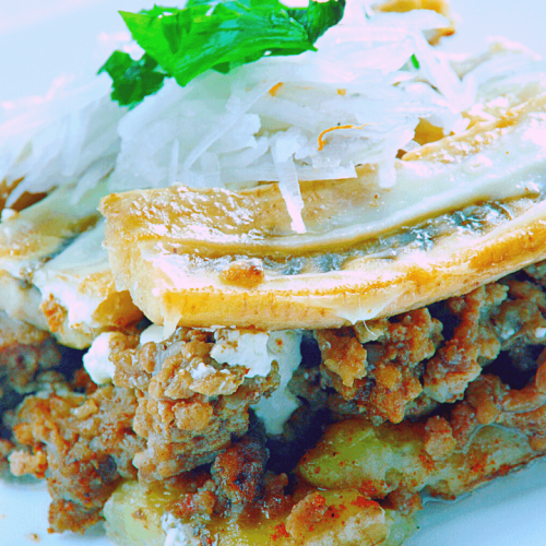 A delicious plate of Pastelón, a healthy Puerto Rican recipe featuring layers of ground beef, plantains, and a topping of fresh onions and cilantro. This Puerto Rican dish is a perfect blend of savory and sweet flavors, showcasing a healthy way to enjoy traditional Puerto Rican cuisine.